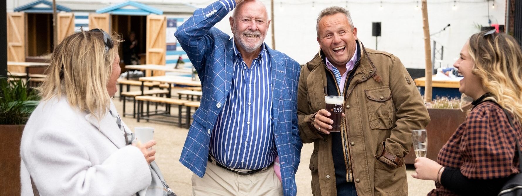 Guests enjoying a lively outdoor event at The Swan Southwold, with people laughing and socialising in the courtyard - showcasing the friendly atmosphere of local events and community gatherings. A glimpse of what's on in Southwold.